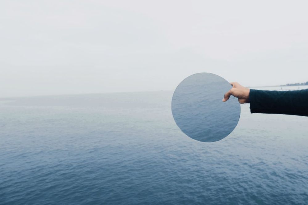 woman-holding-mirror-over-water-self-reflection-in-leadership-development-1024x683.jpg