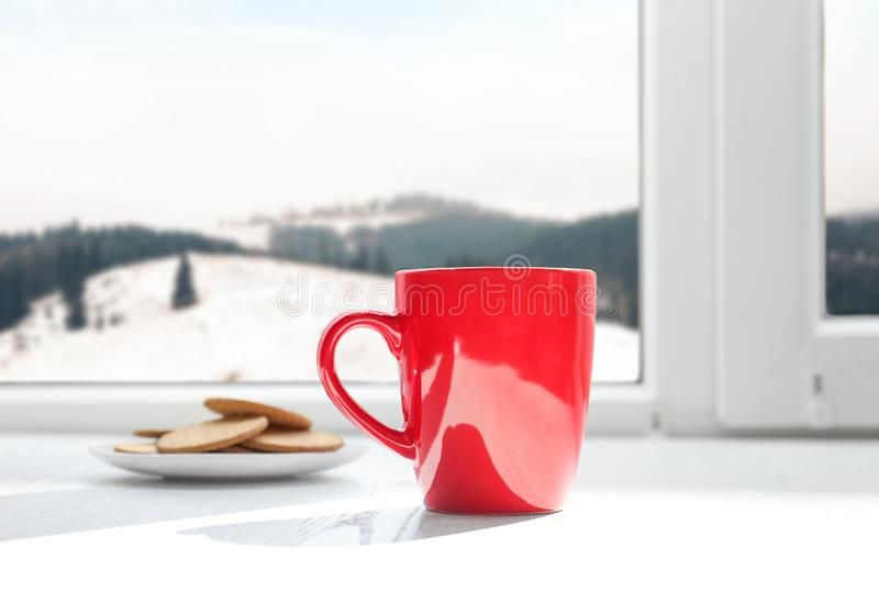 hot-drink-cookies-near-window-view-winter-mountain-landscape-152877428.jpg